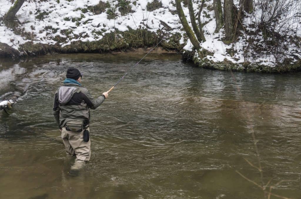 fishing for trout in stream in winter